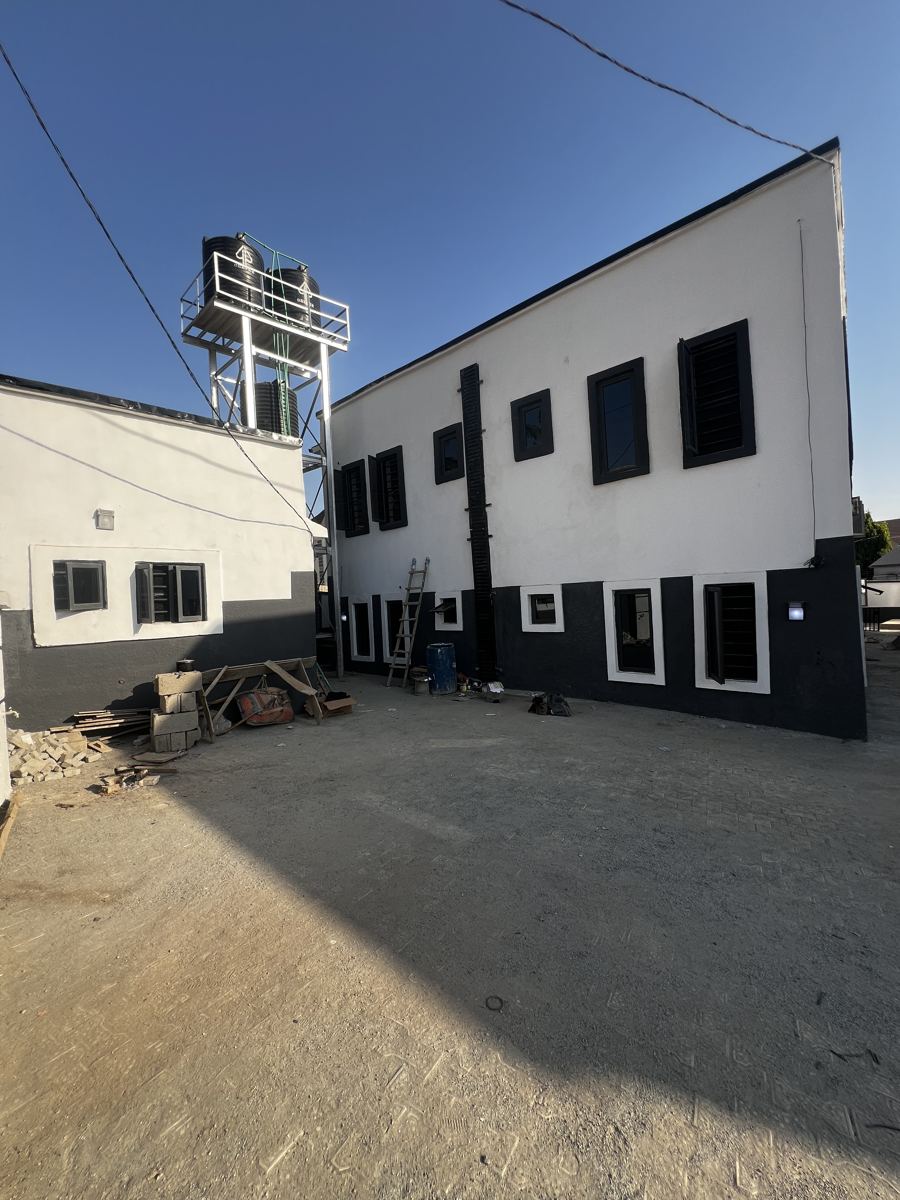 Completed two-storey Vidys building in Abuja with external painting finished and elevated water-tank tower installed